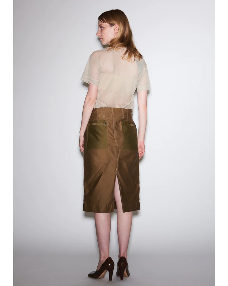 メッシュ素材で透け感のあるベージュのシャツを着用した女性