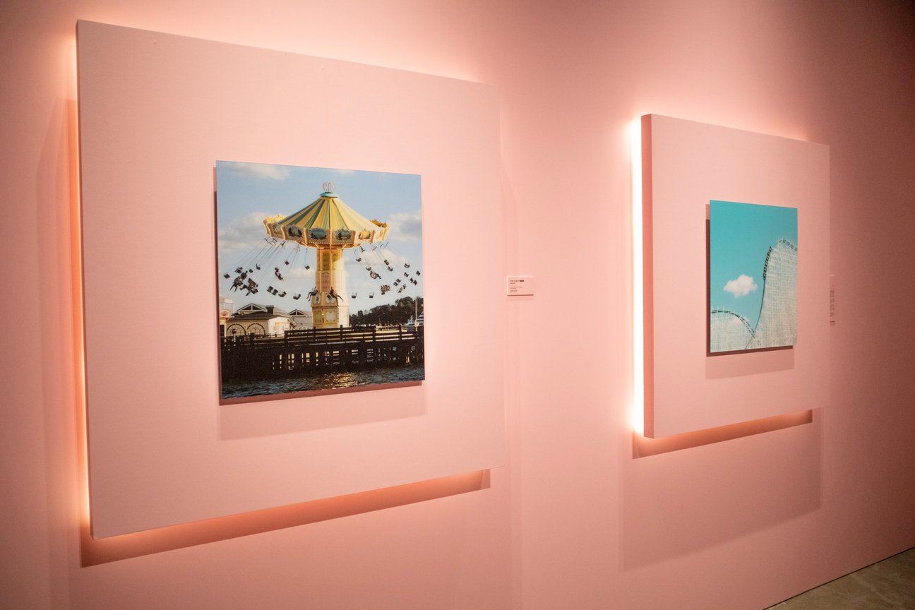 ピンクの壁にかけられた写真作品
