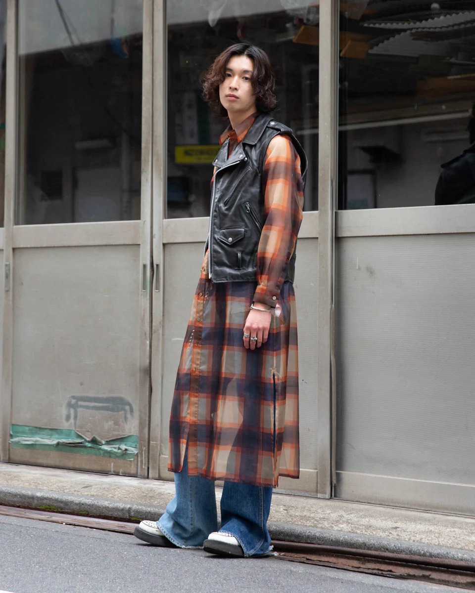 オレンジチェックのレイヤードロングシャツを着た男性