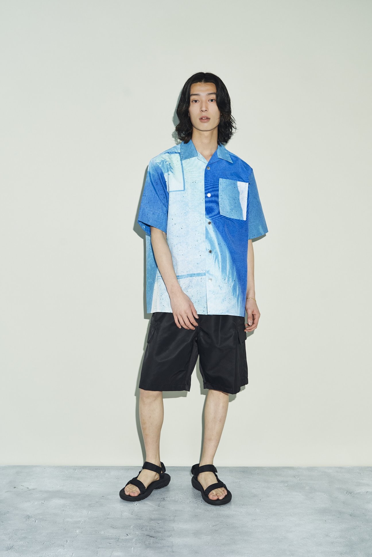 ブルーのグラフィックシャツを着た男性