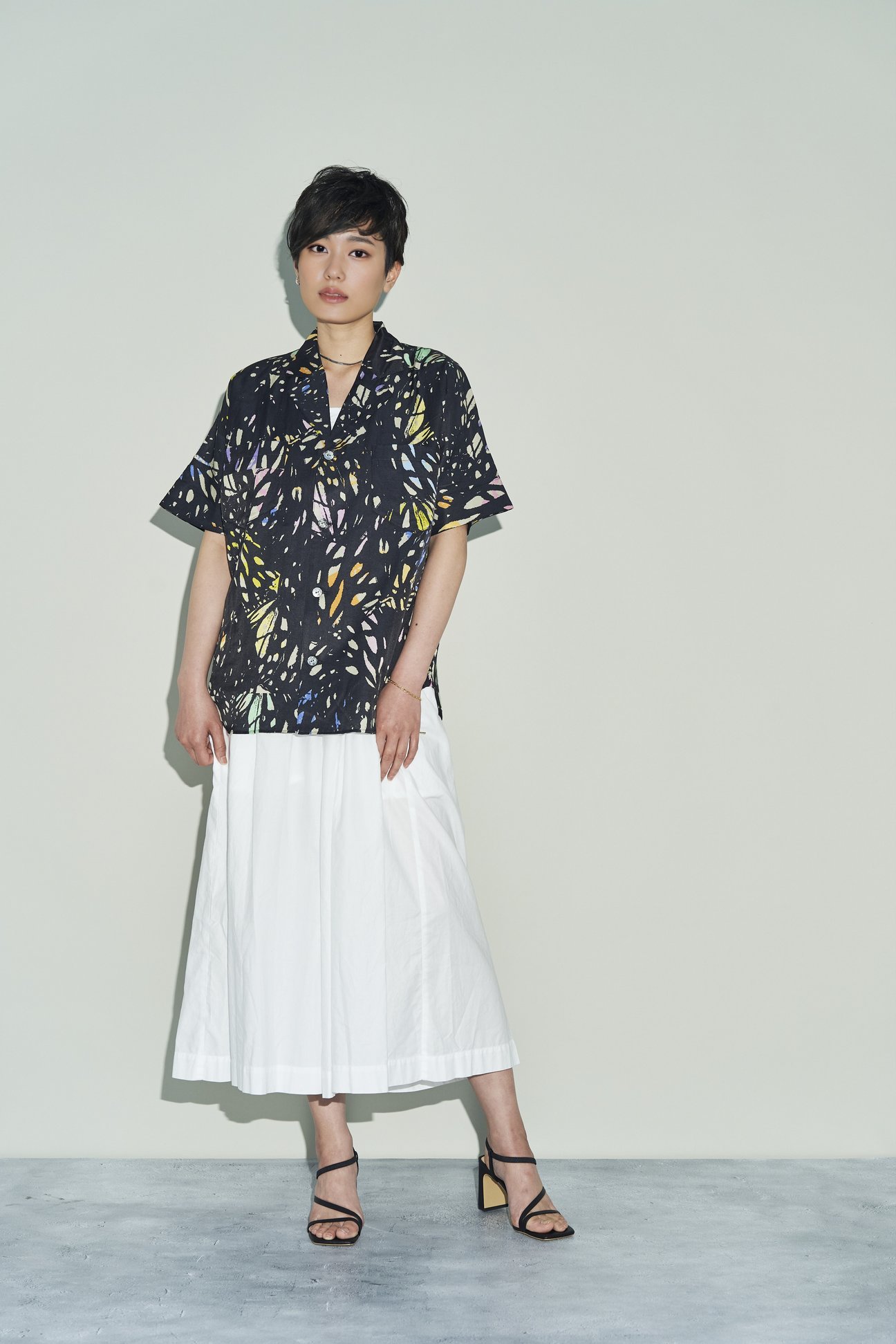 TANAKAのプリントシャツを着た女性