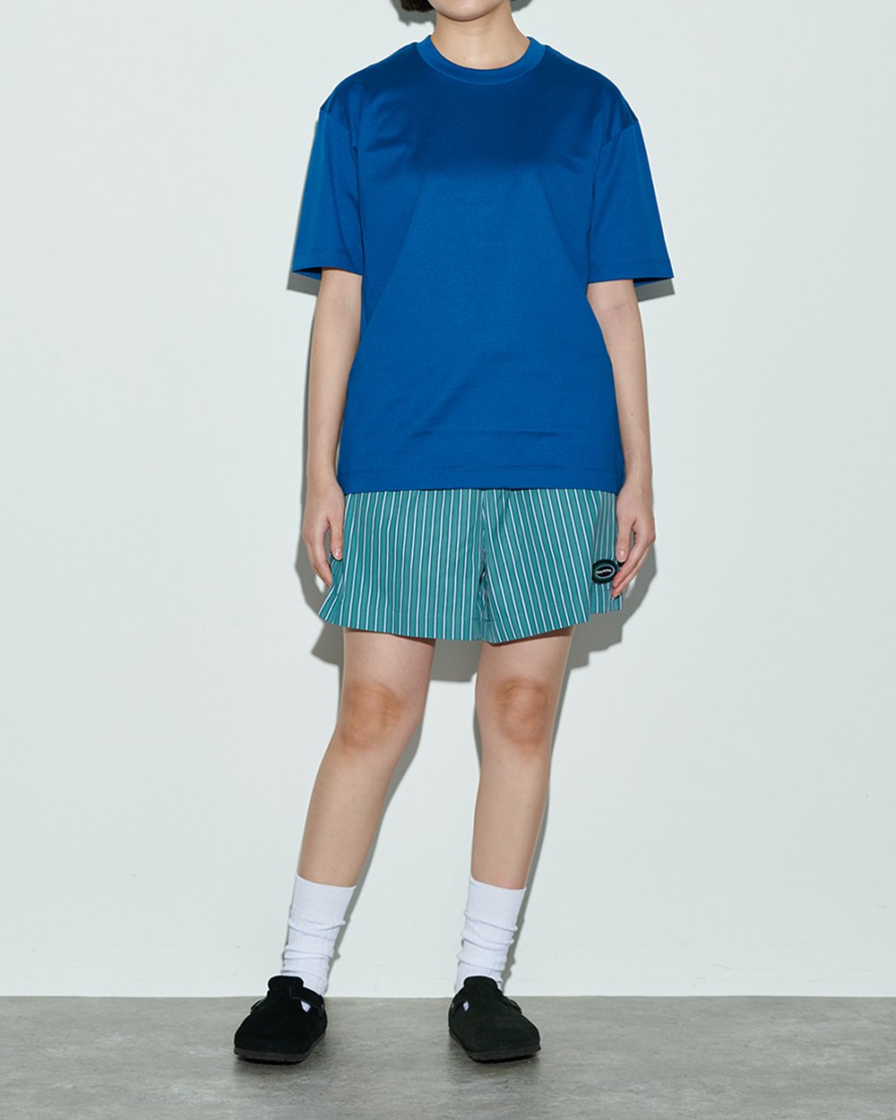 チノのブルーのTシャツを着用した女性モデル