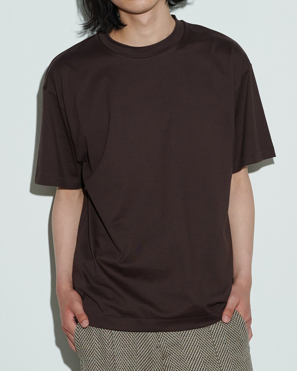 エイトンのバーガンディーカラーのTシャツを着用した男性モデル