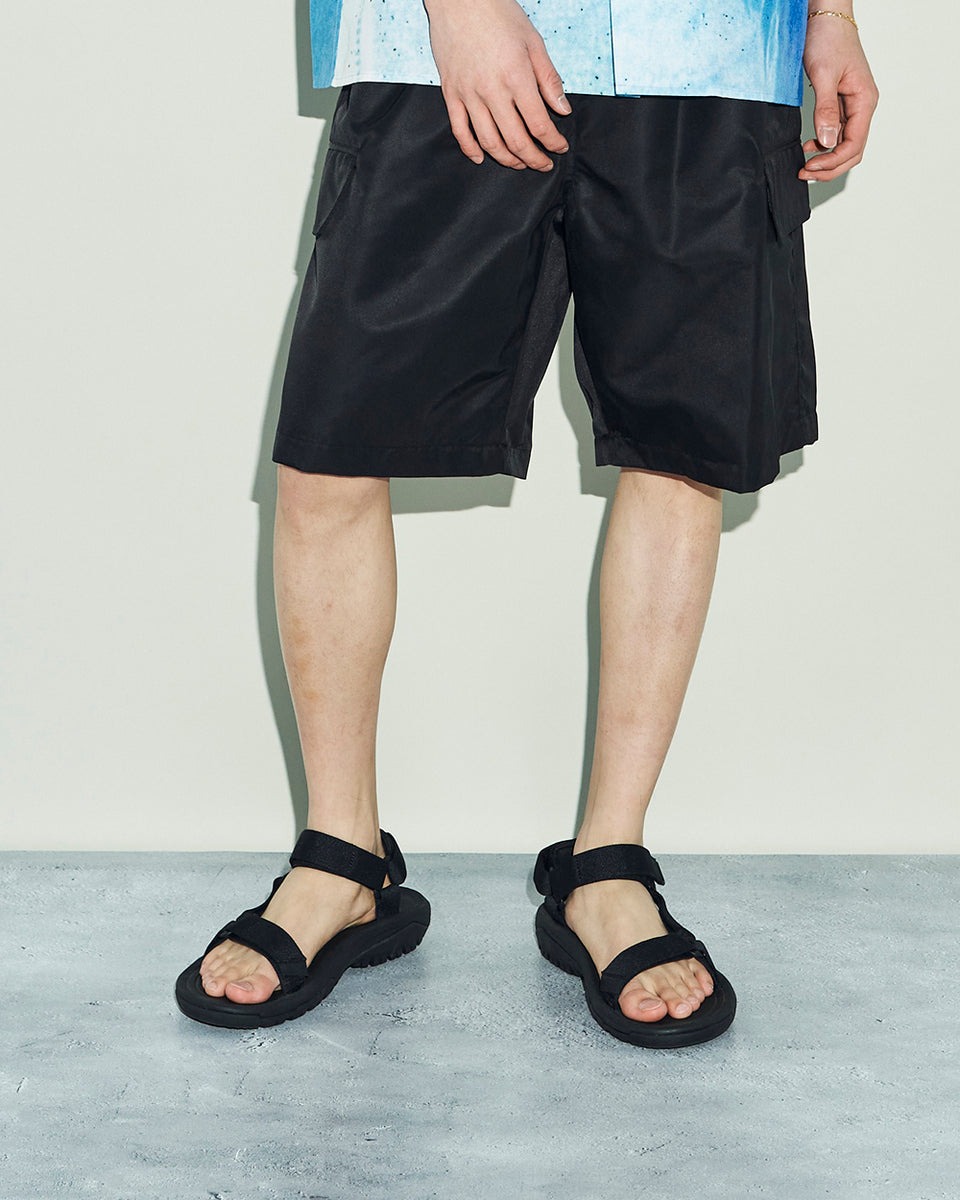 男性の着用写真。ハーフパンツとブルーのシャツのスタイリング
