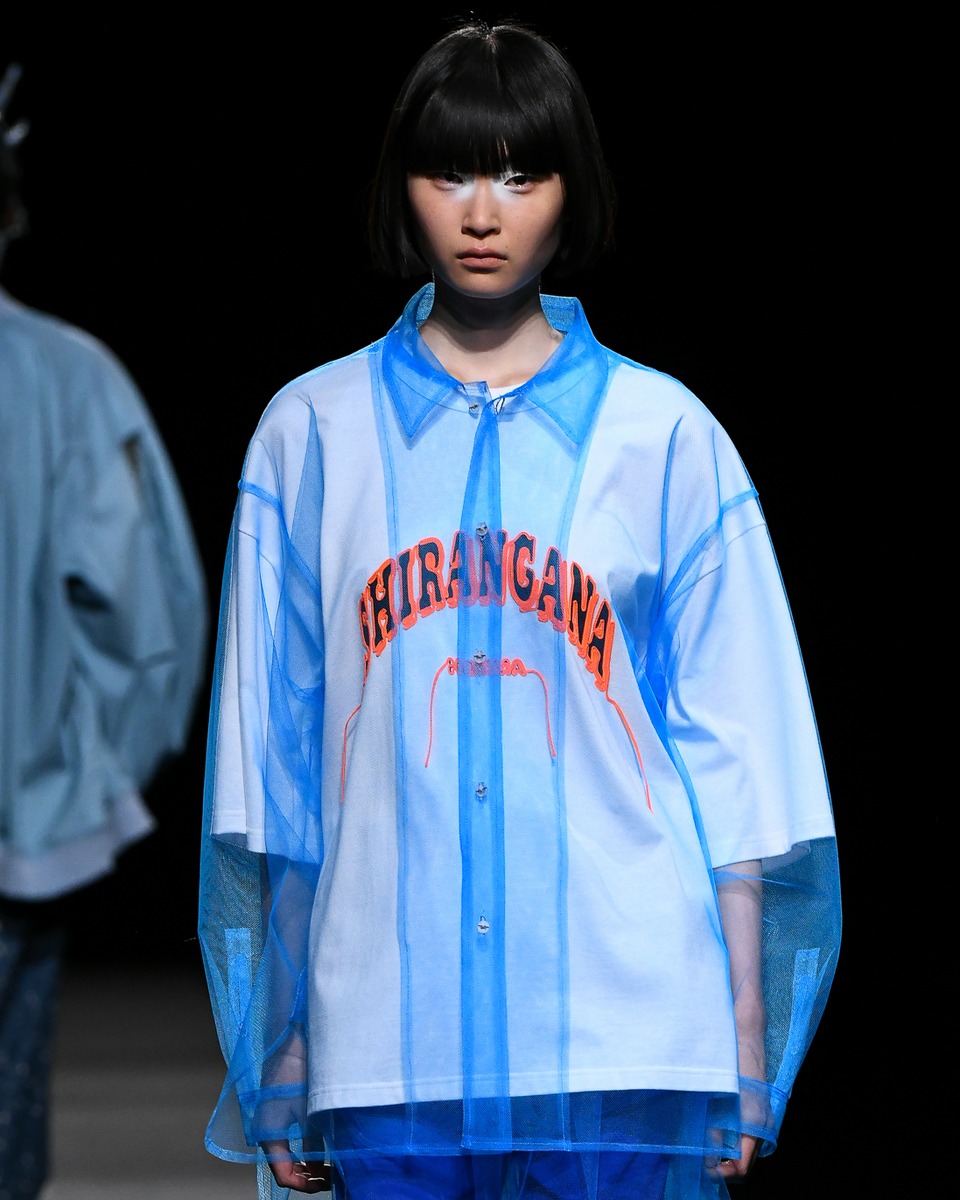 Tシャツとのレイヤードコーディネートでショーを歩く女性