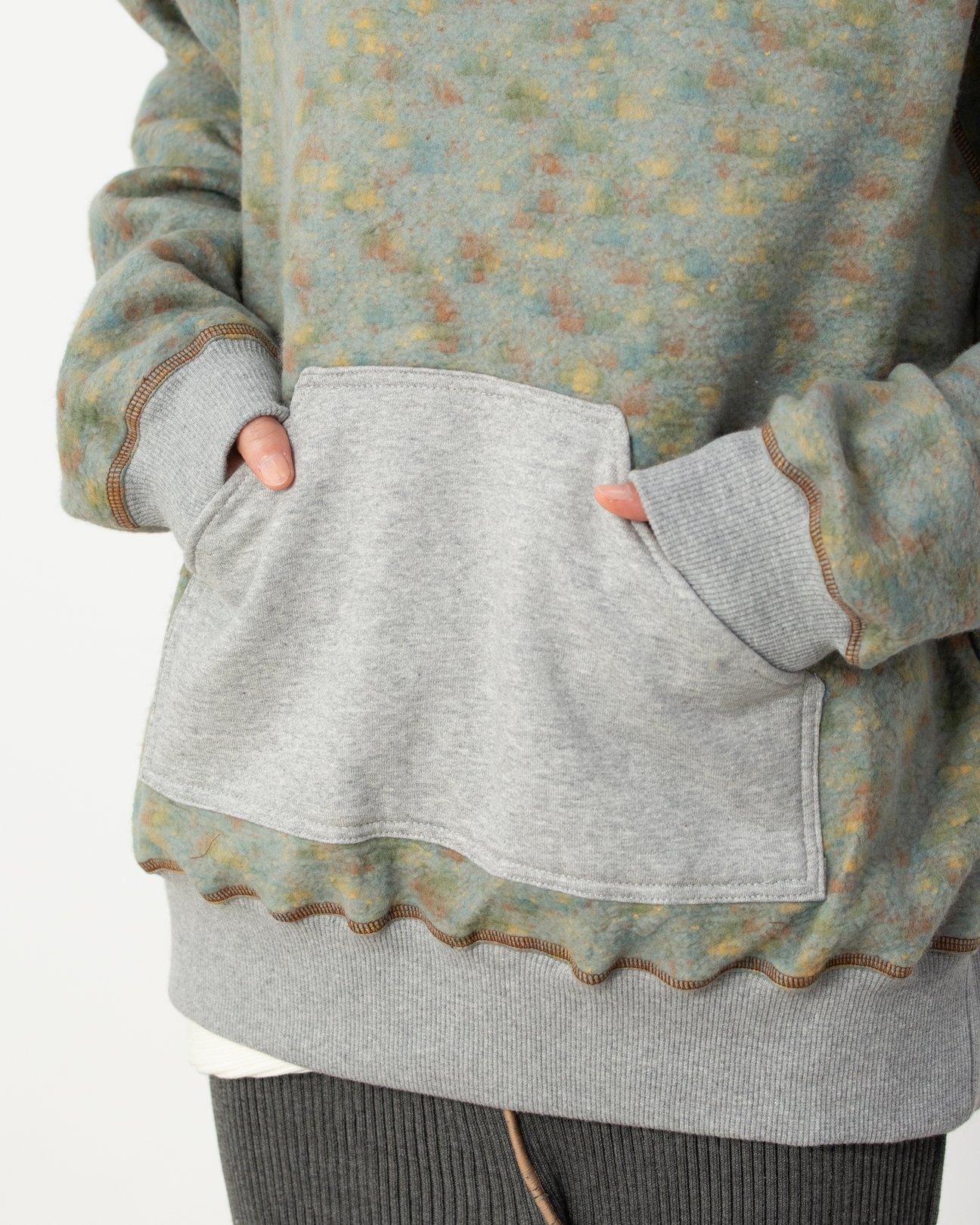 グレーのパーカーとスカートのスタイリングを着用した女性。