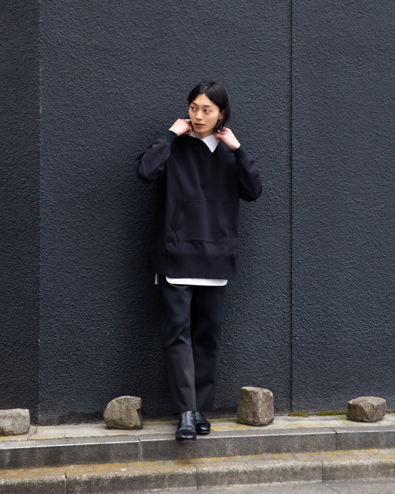 ブラックのパーカーを着用した男性のスナップ写真。