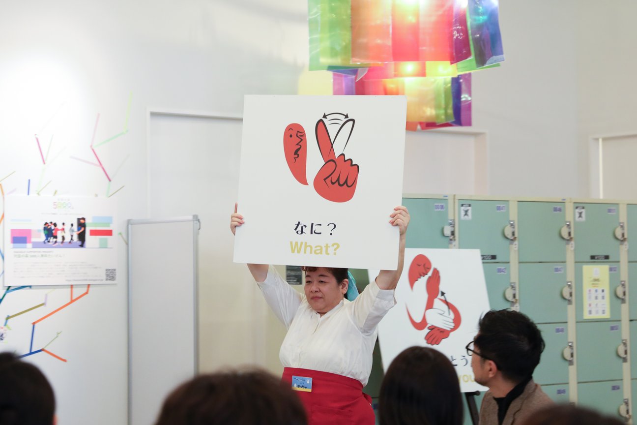 手話のカードを持った女性