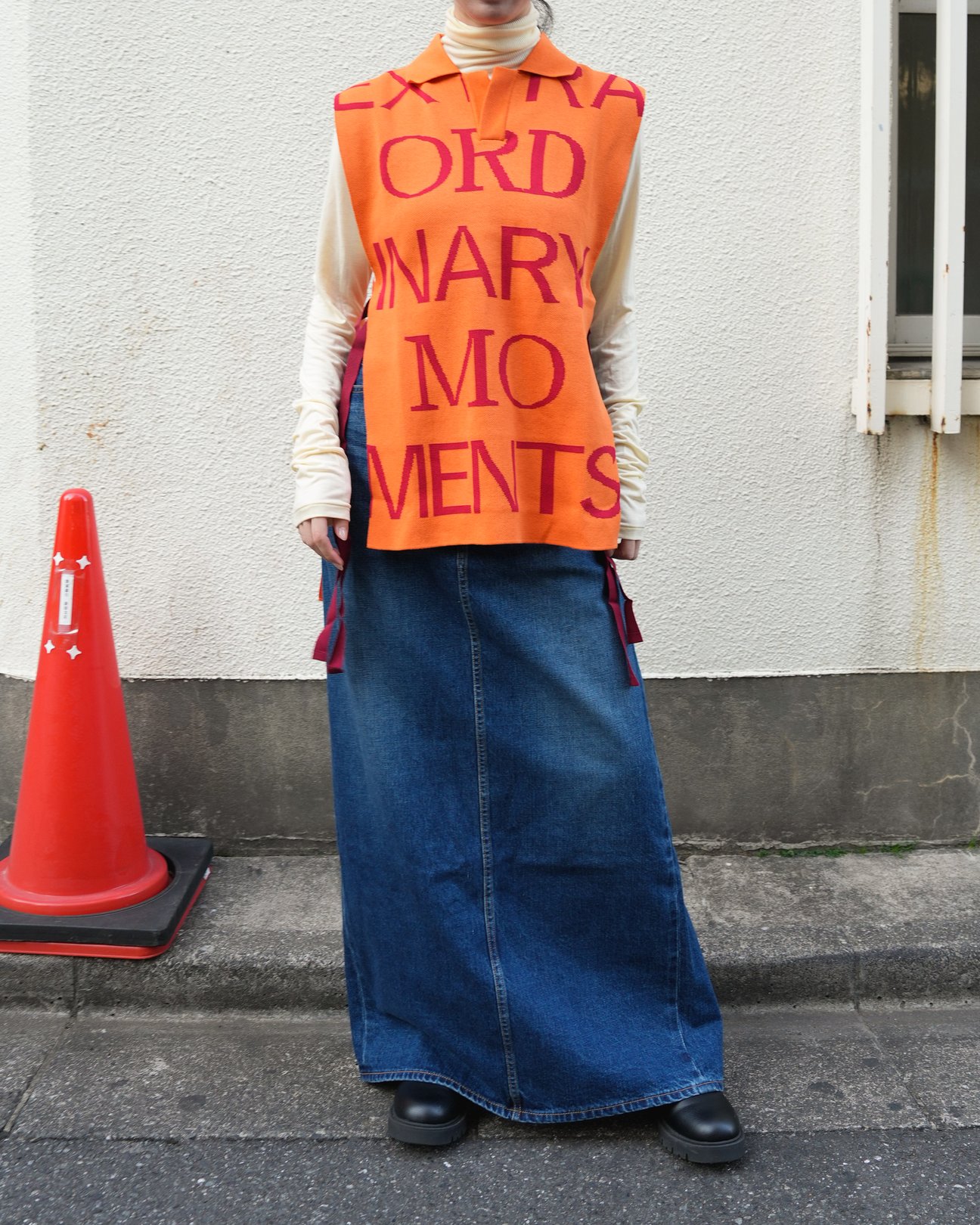 女性の着用写真。ホワイトのトップスとのレイヤード。