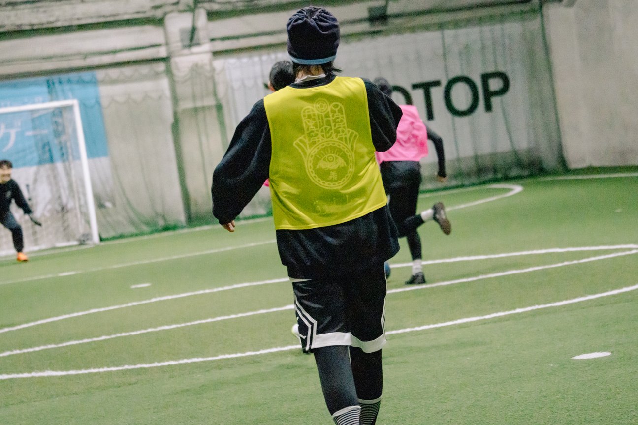 サッカーをしている男性の後ろ姿