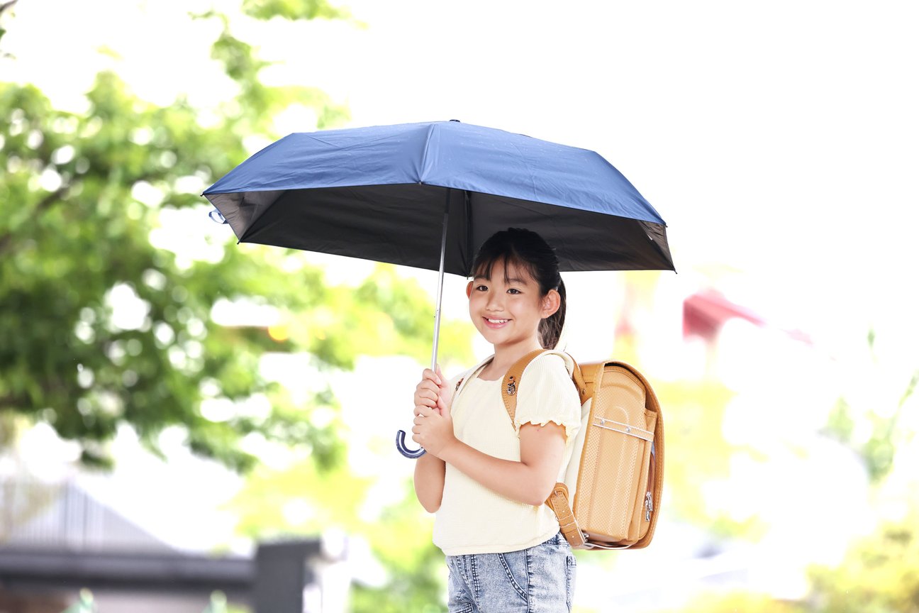「LINE DROPS キッズ晴雨兼用折りたたみ日傘」を差す小学生女子