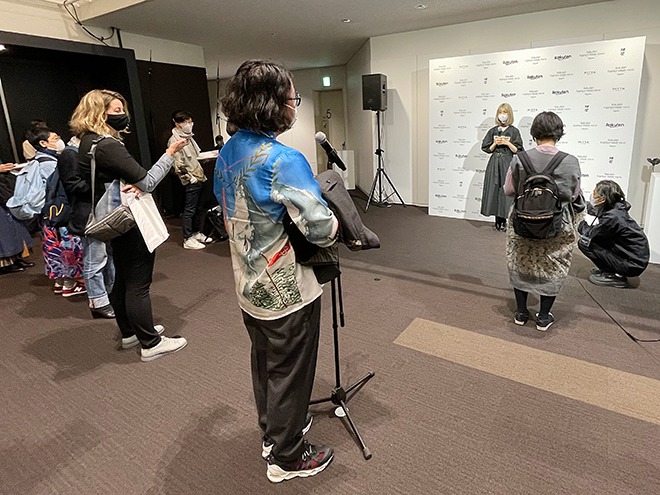 <MIKAGE SHIN(ミカゲシン)>のショー終了後、デザイナーに質問するファッションジャーナリストの増田海治郎さん。