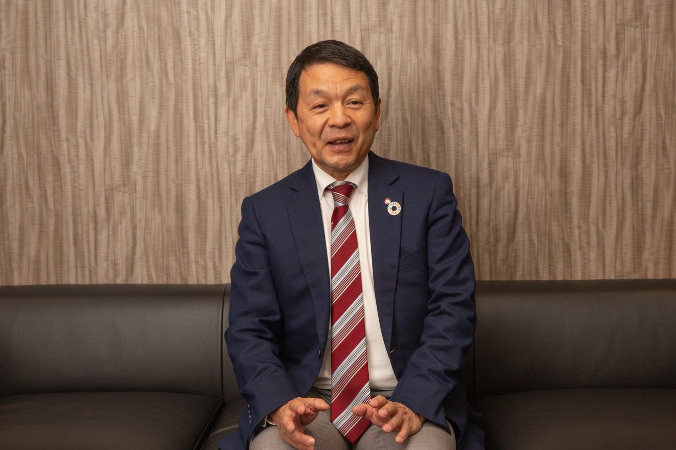 ソファに座ってインタビューに応じる近藤社長