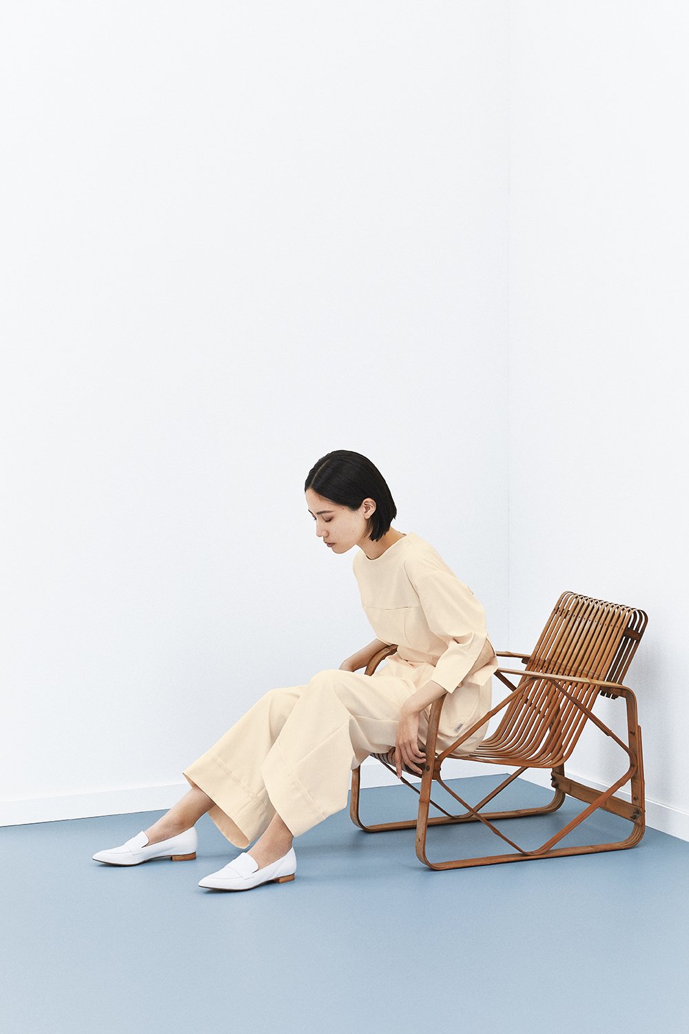 クリームカラーの洋服を纏った女性モデル