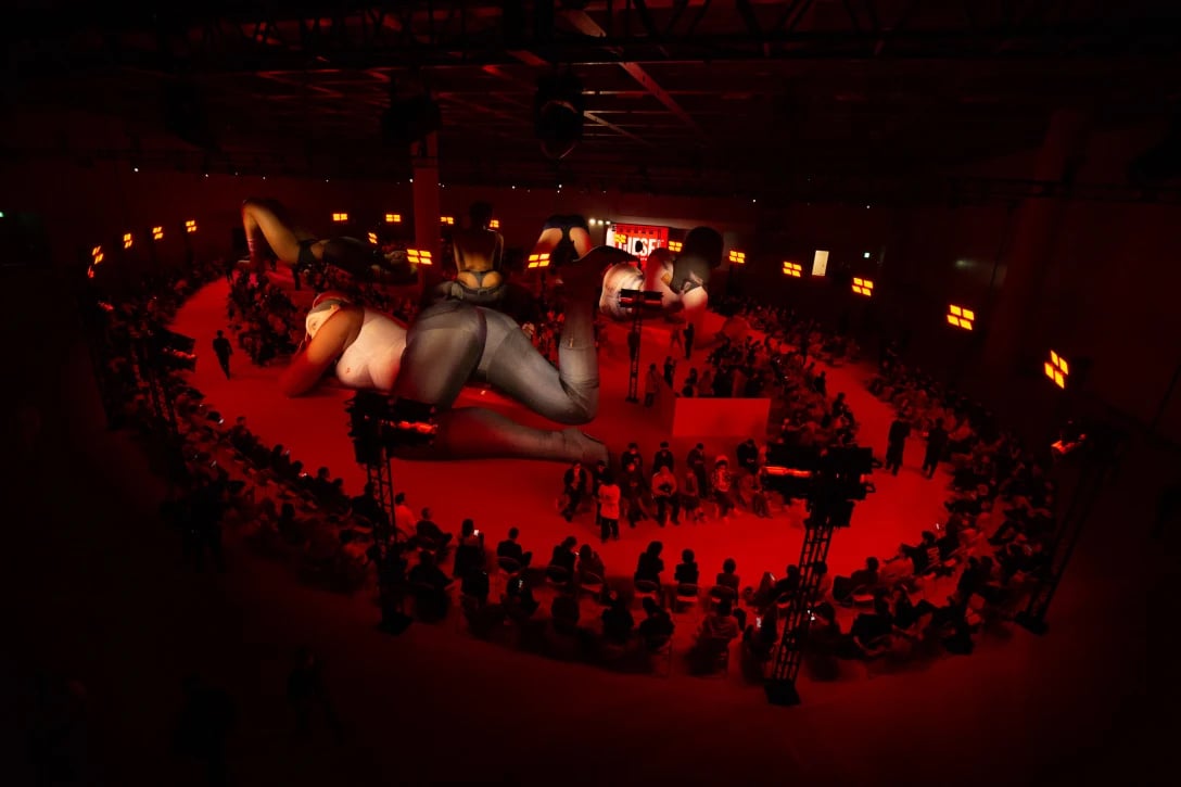 人型の巨大なバルーンが置かれたファッションショー会場