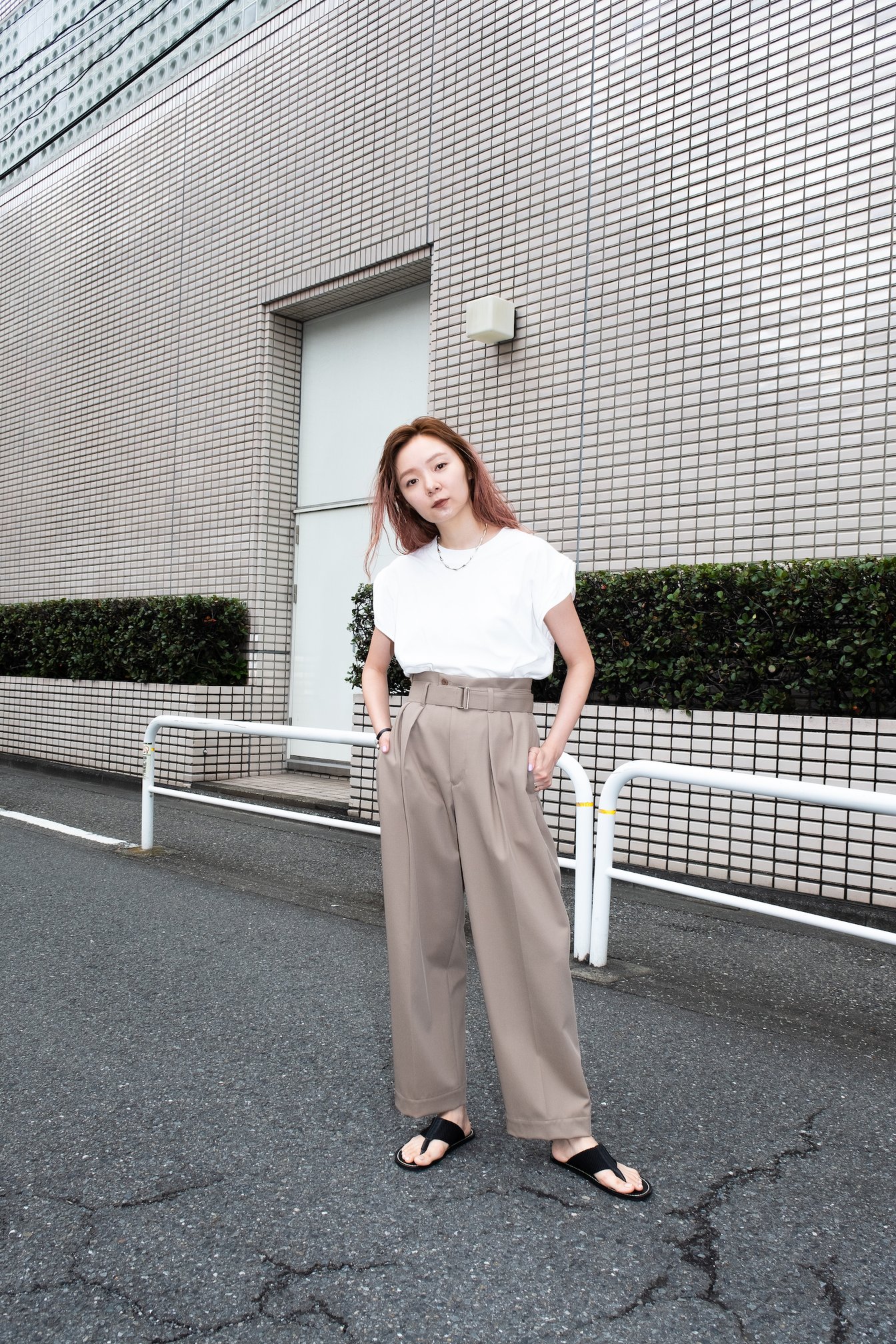 ベージュのパンツに白Tを合わせた女性モデル