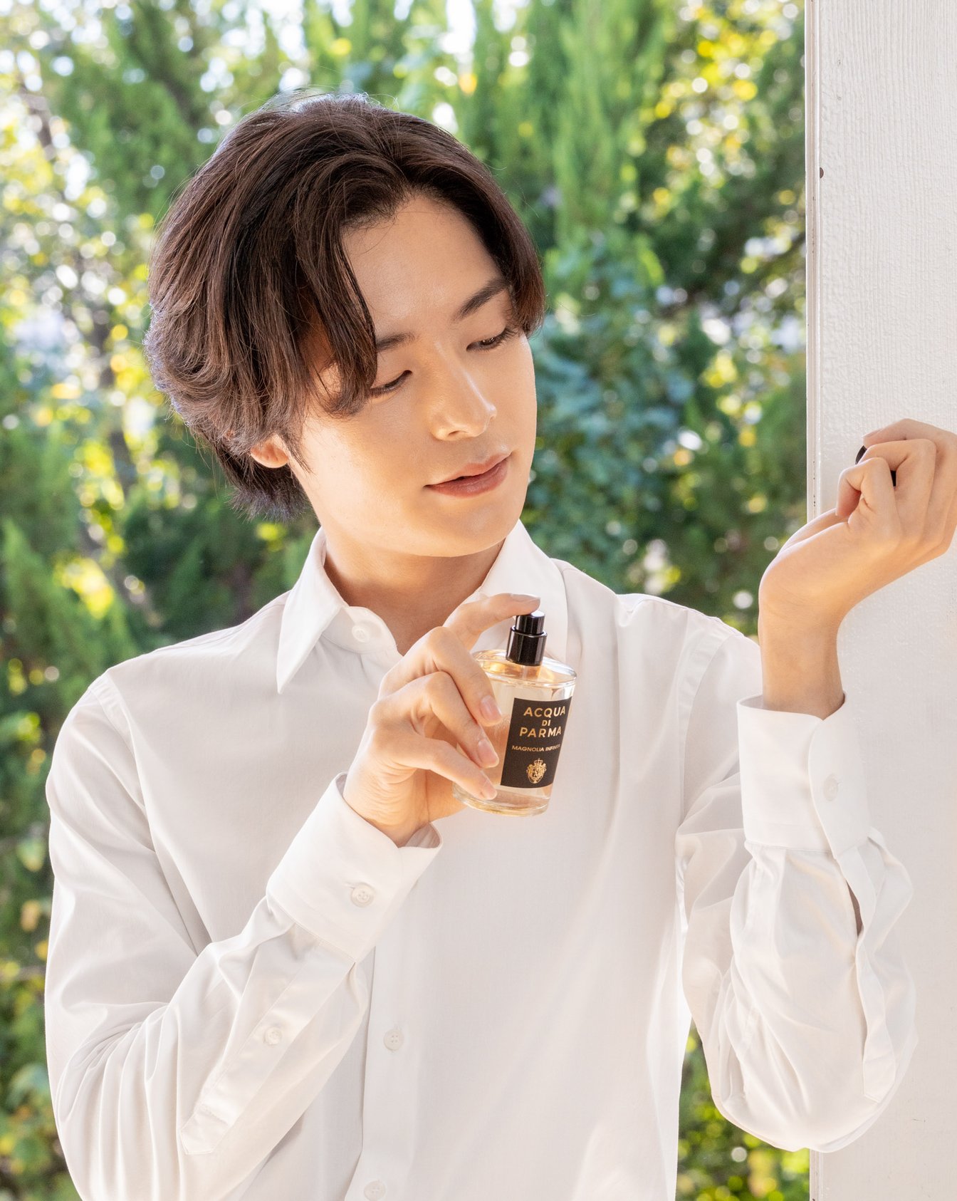 手首に香水を吹きかける男性