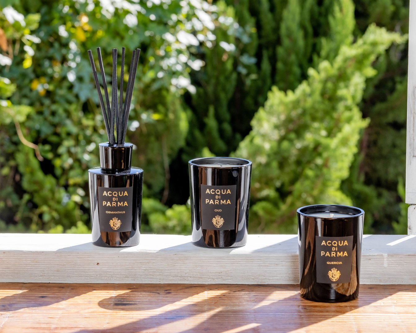 日当たりのよい窓際に並んだ黒い容器のディフューザーとキャンドル