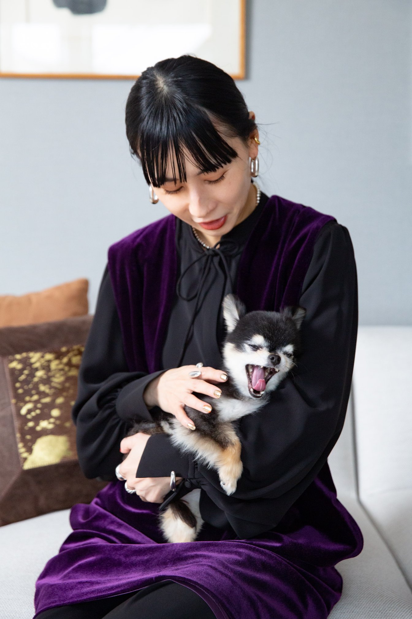 あくびをする愛犬を抱きかかえる黒石