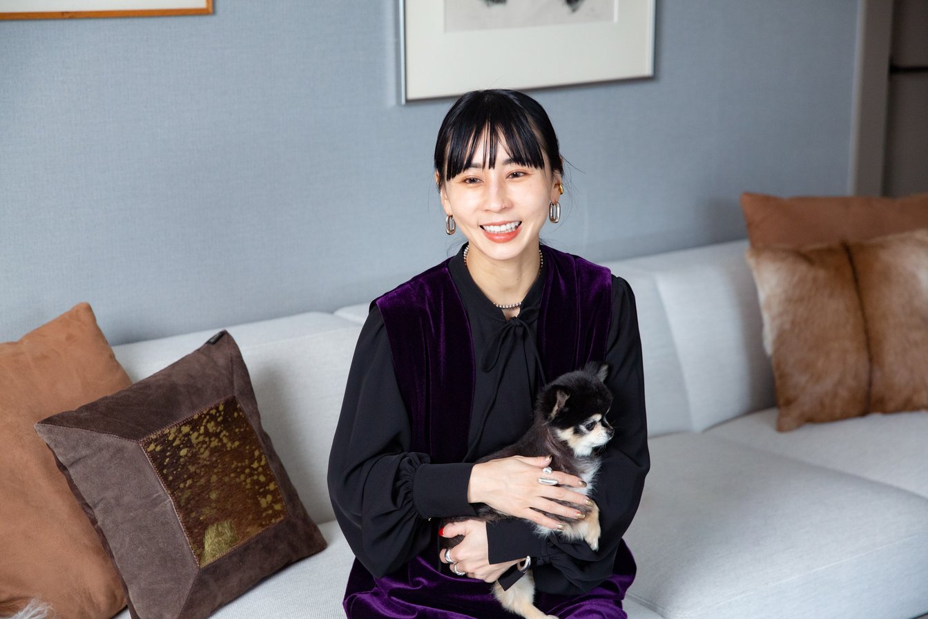 愛犬を抱えながら笑顔で話す黒石