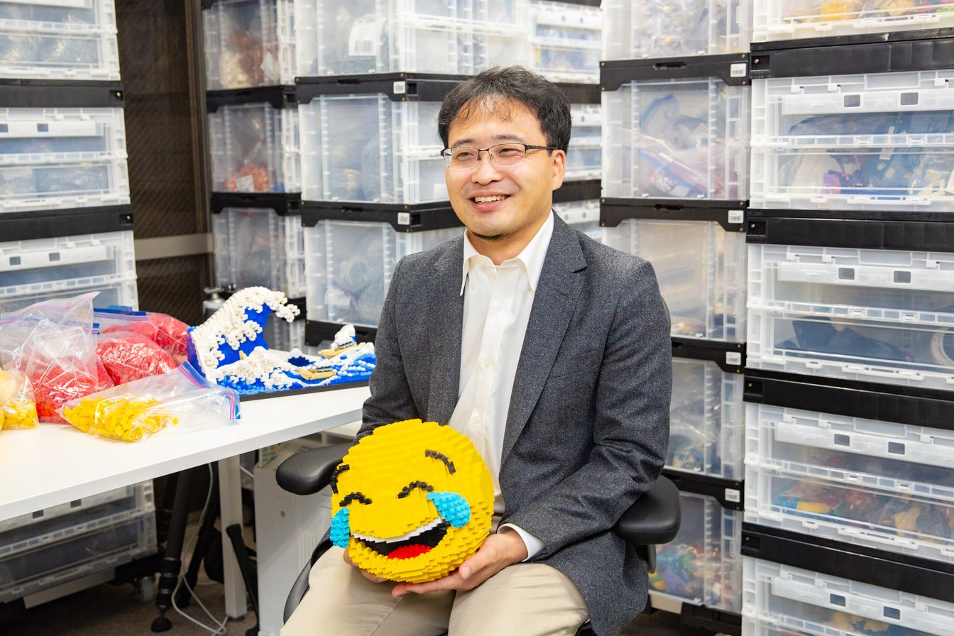 レゴブロックで作られた絵文字を持つ男性