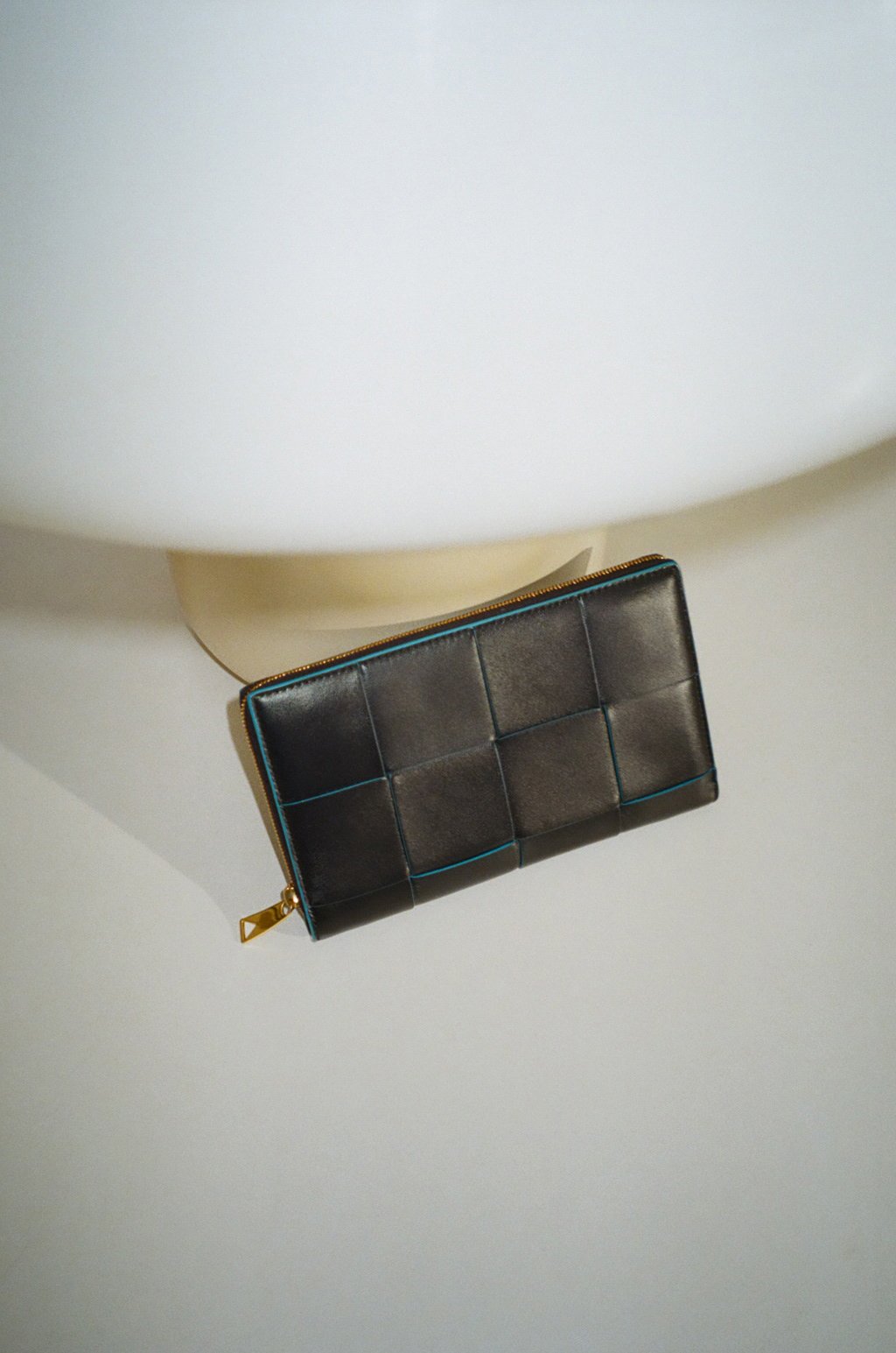 編み込まれたレザーのリムから鮮やかなブルーを覗かせて。ウォレット(SPACE-POOL)(H11.5×W19×D2cm)15万4000円(日本限定色)