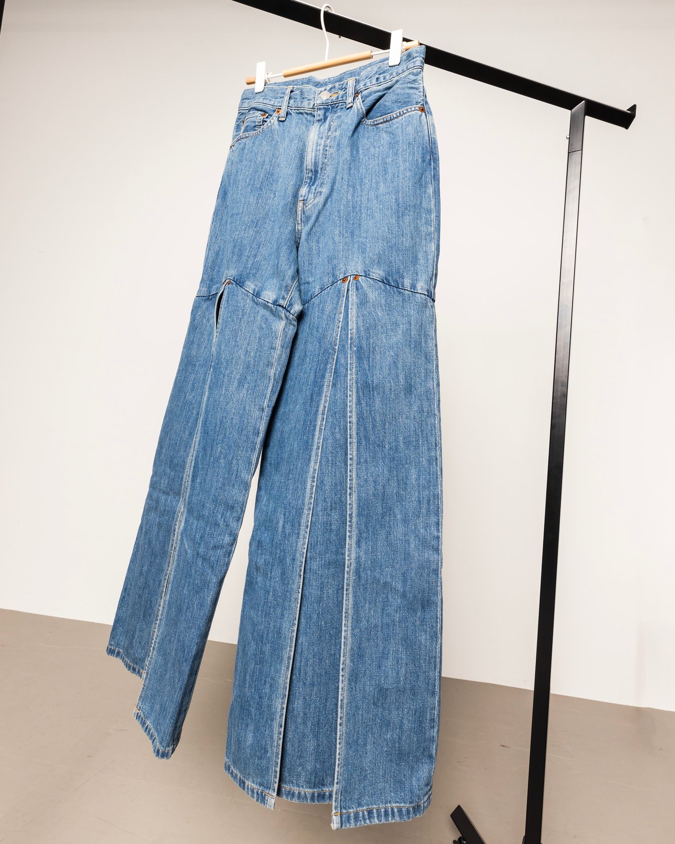 ラックにかけられたライトブルーのデニムパンツ