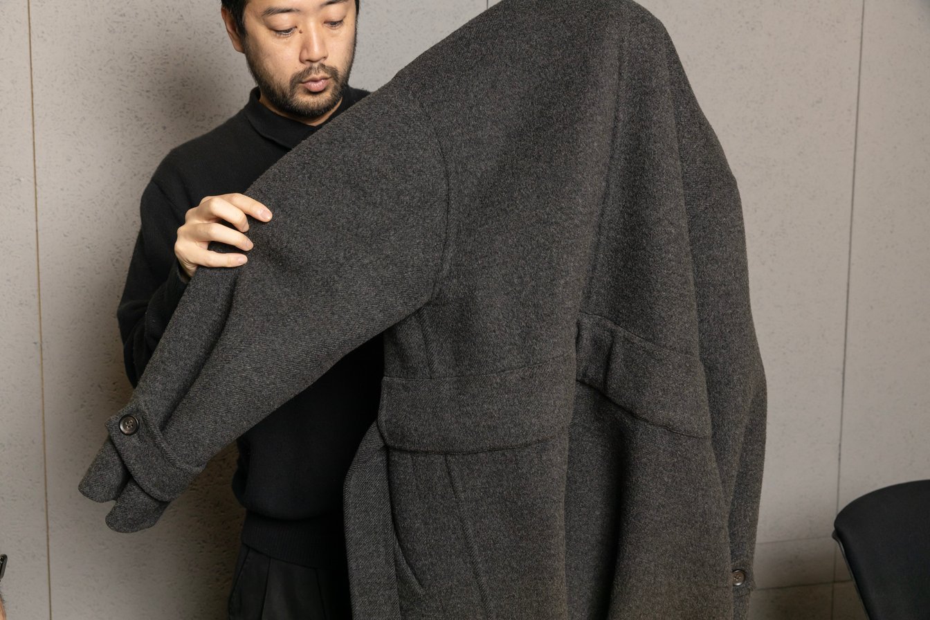 コートを解説する男性デザイナー
