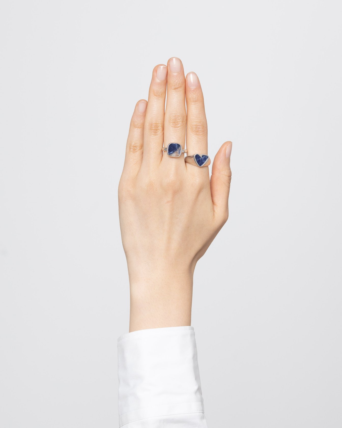 ハートのリングとスクエアのリングをつけた手元