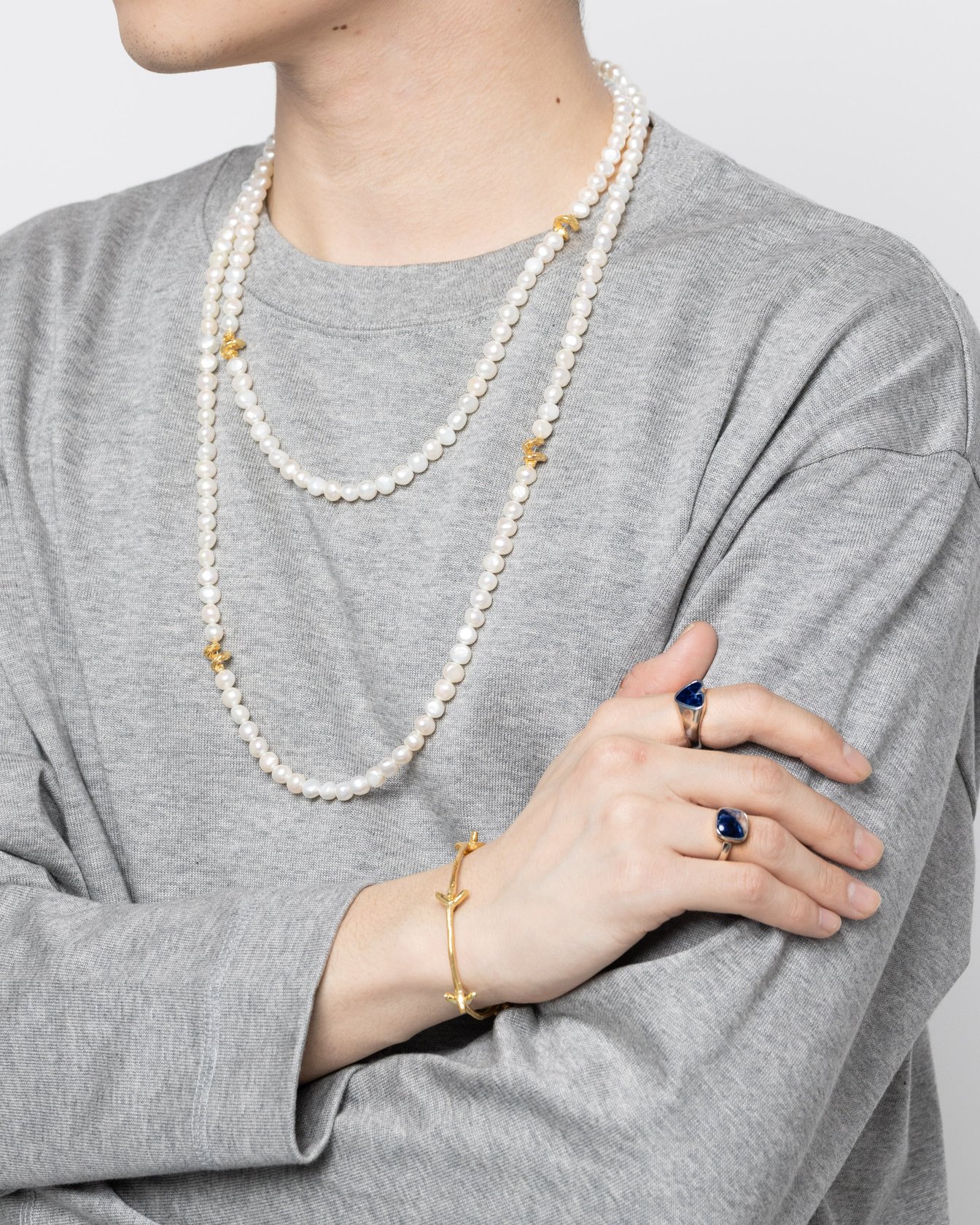 パールネックレスを身につけた男性モデル