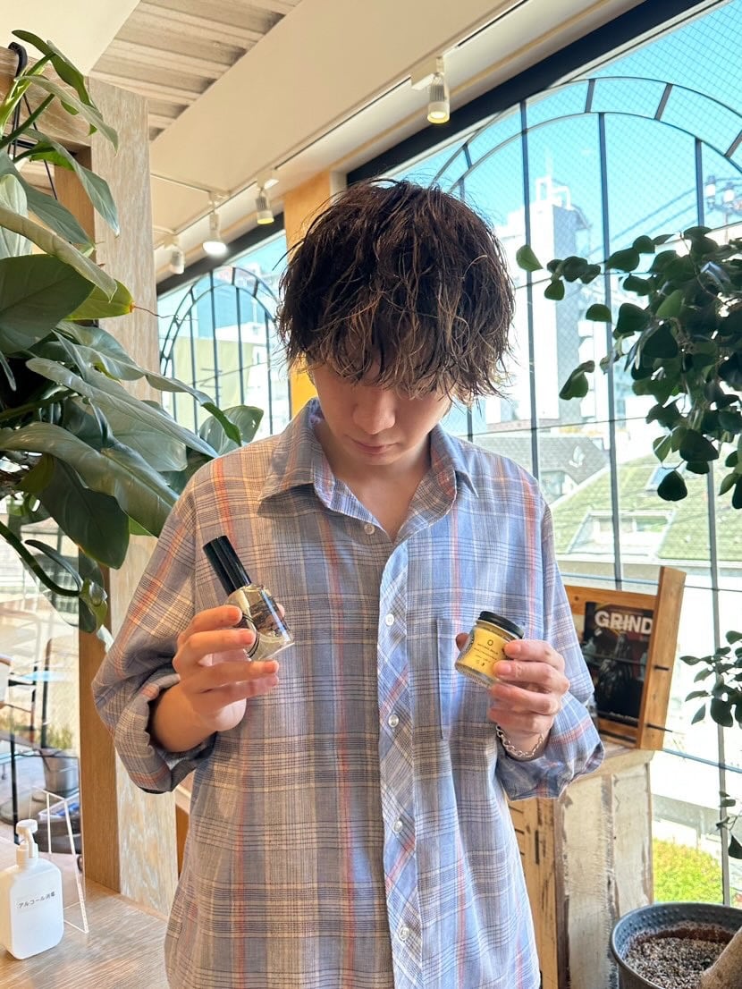 O skin&hairのオイルとバームを手に持った男性