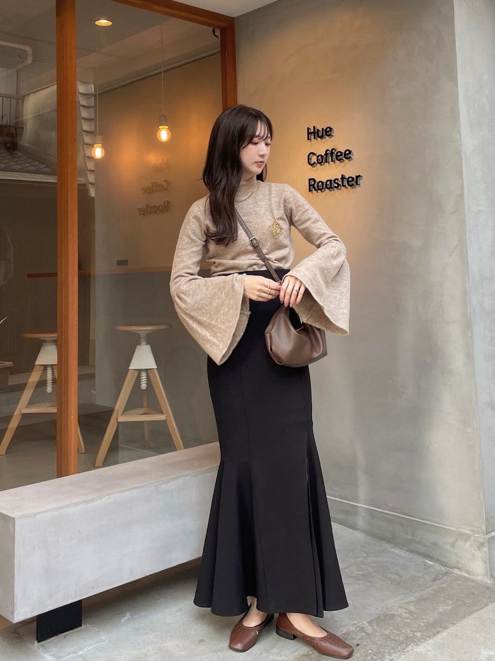 ベージュのカットソーと黒いスカートを着用した女性
