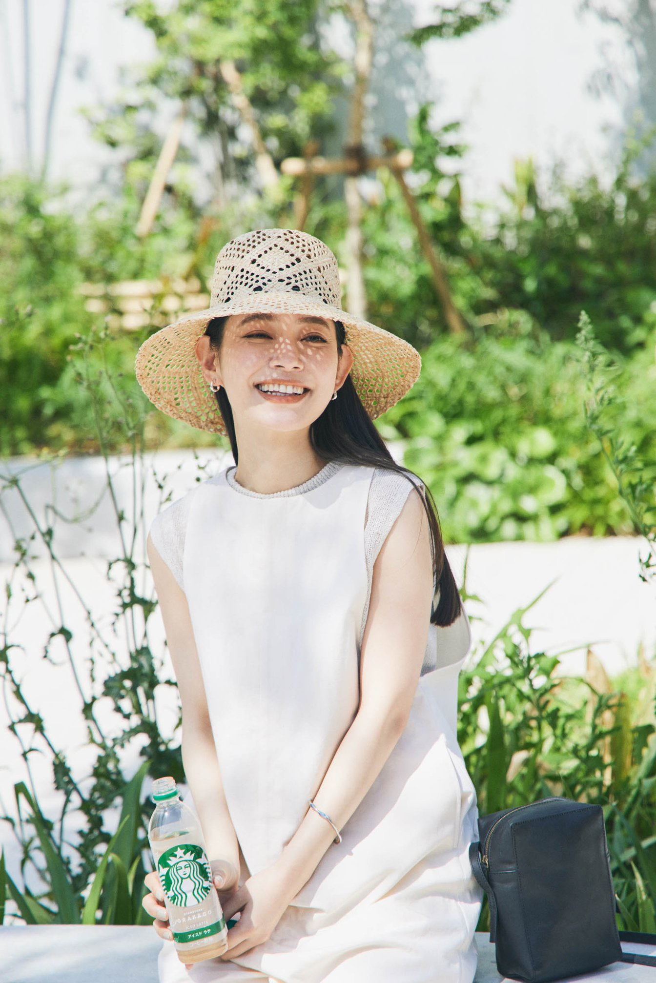 スターバックスのボトルと笑顔の女性