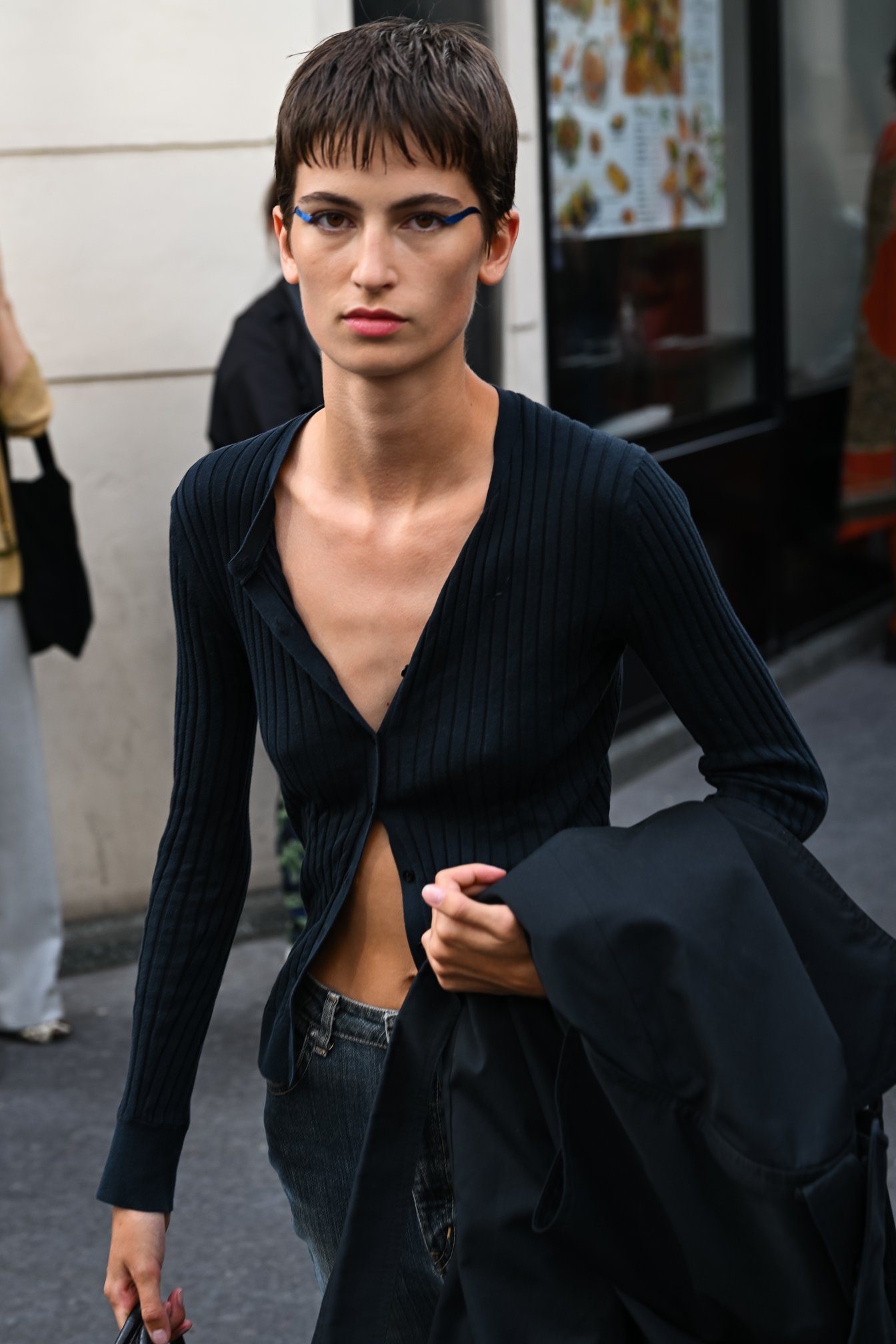 リブカーディガンをラフに羽織って素肌を見せるモデルの私服コーデ。