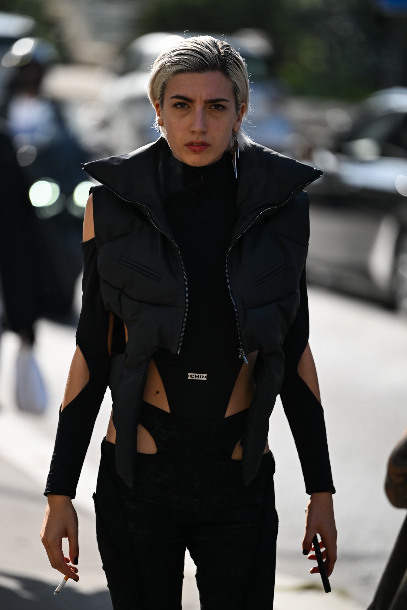 カットアウトされたボディスーツで脇腹や腕を見せるブラックコーデ。