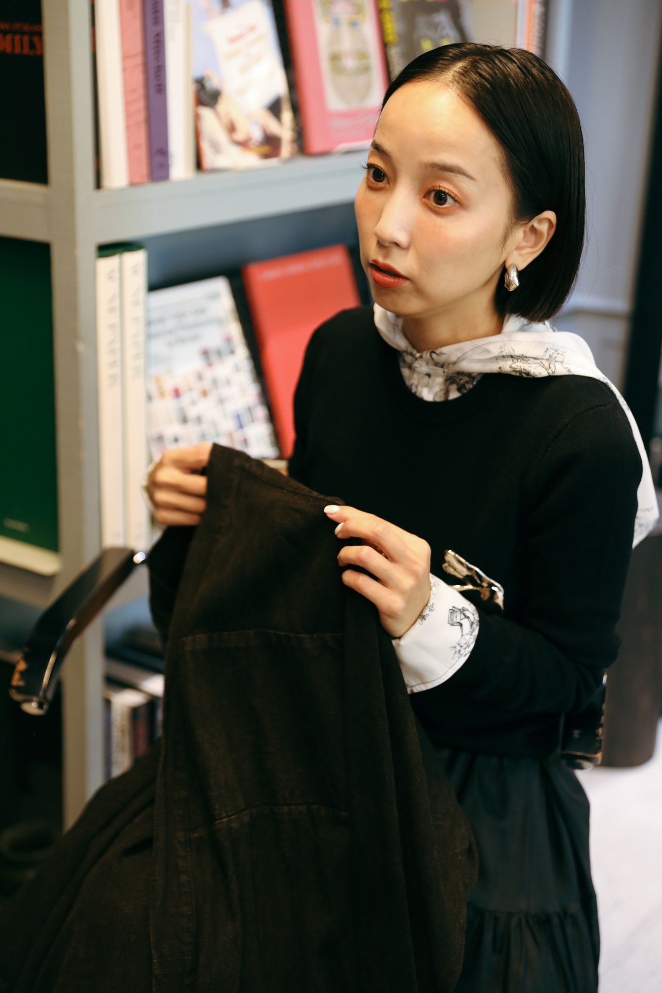 瞑想着を手に持って話す長尾悠美