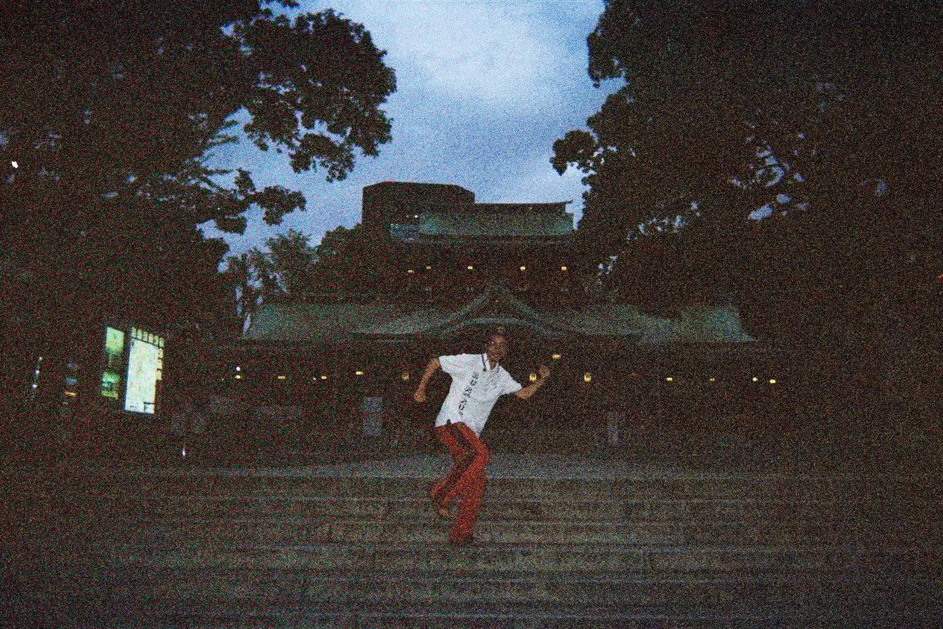 富岡八幡宮の前でポーズをとる田中俊行