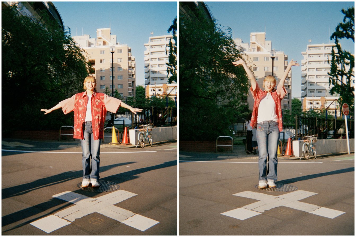 飯倉公園をバックに道路でポーズを取る佐々木莉佳子