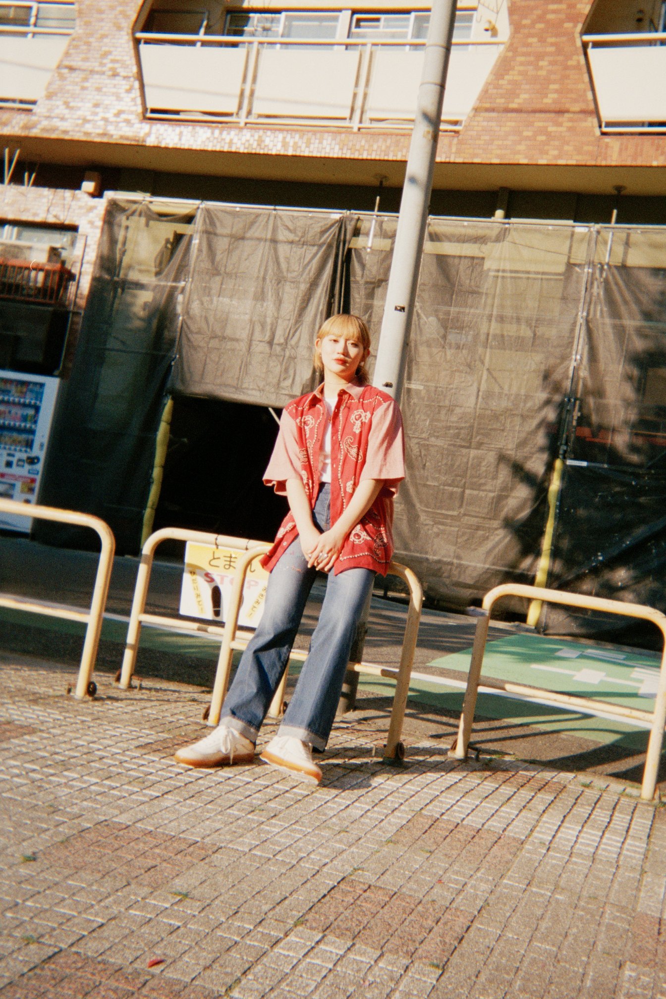 公園の柵に腰掛ける佐々木莉佳子