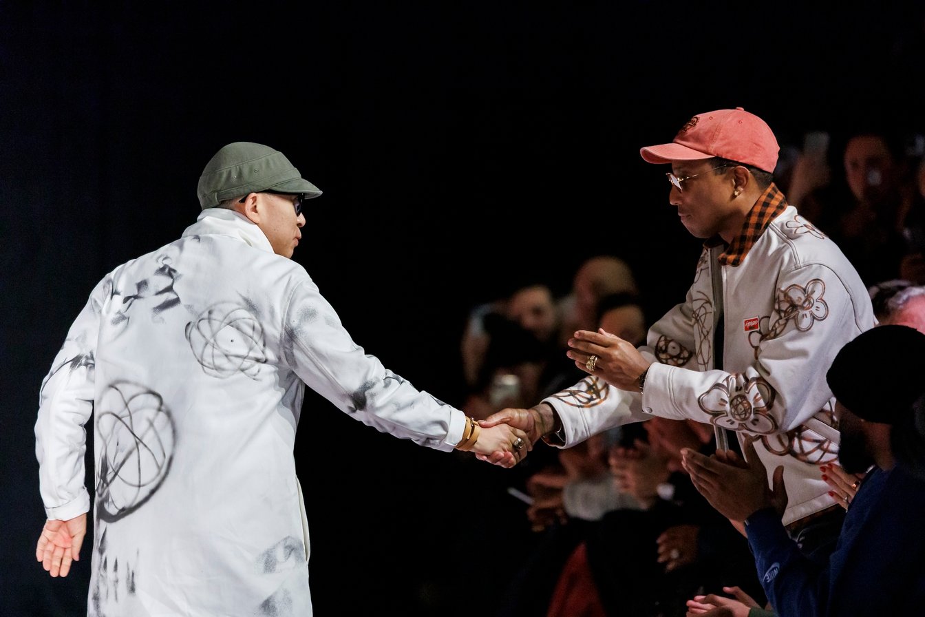 KENZOのフィナーレで客席のファレル?ウィリアムスと握手を交わしたNIGO