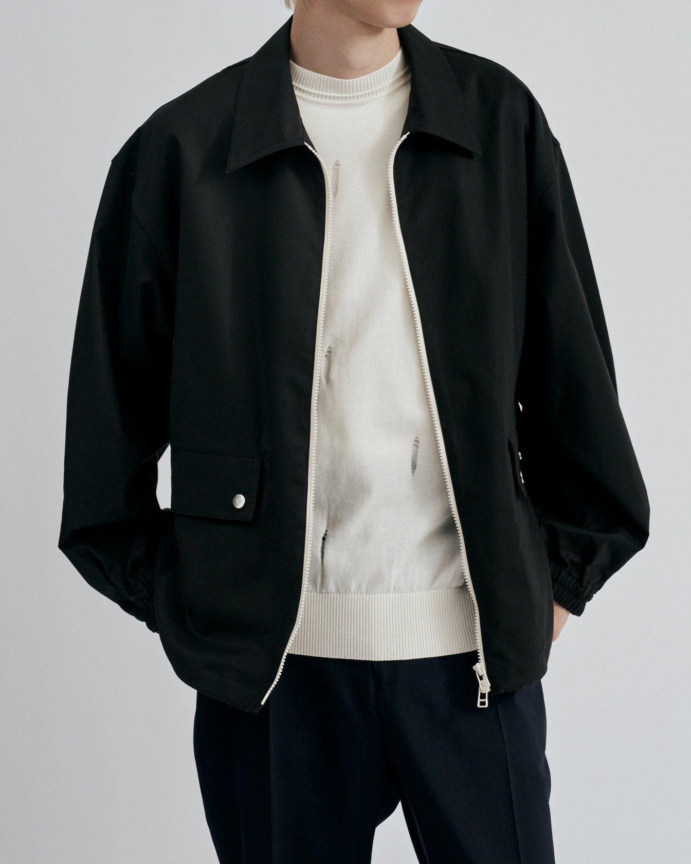 チノのジップアップブルゾンを着たモデル