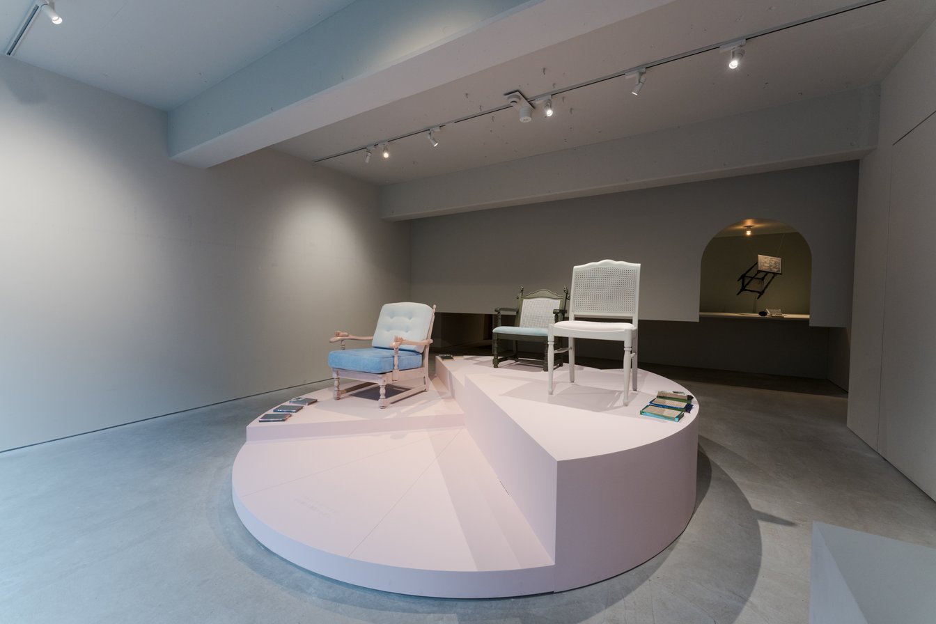 時計をイメージした円形の台に展示された3脚の椅子