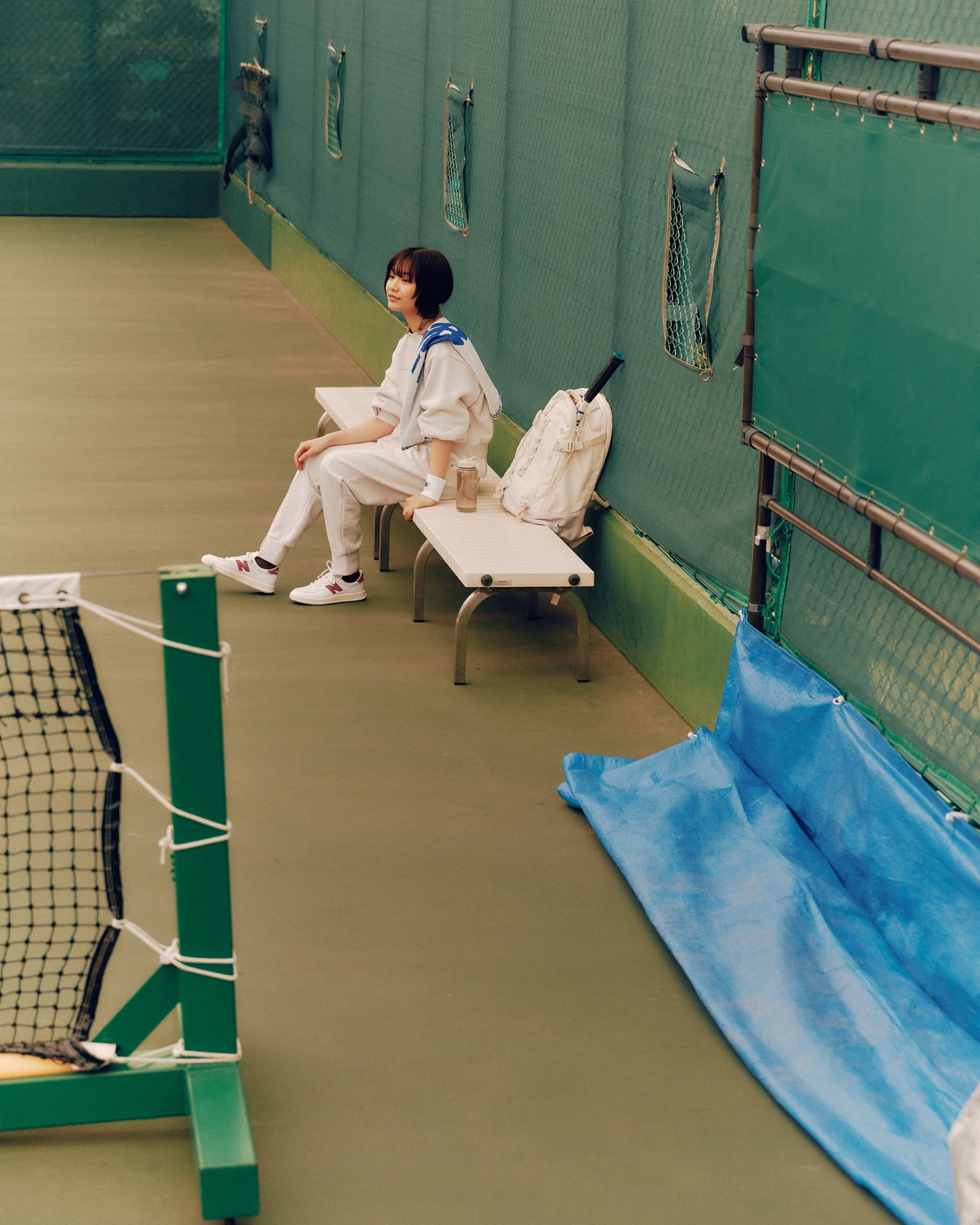 テニスコートのベンチに座るモデル