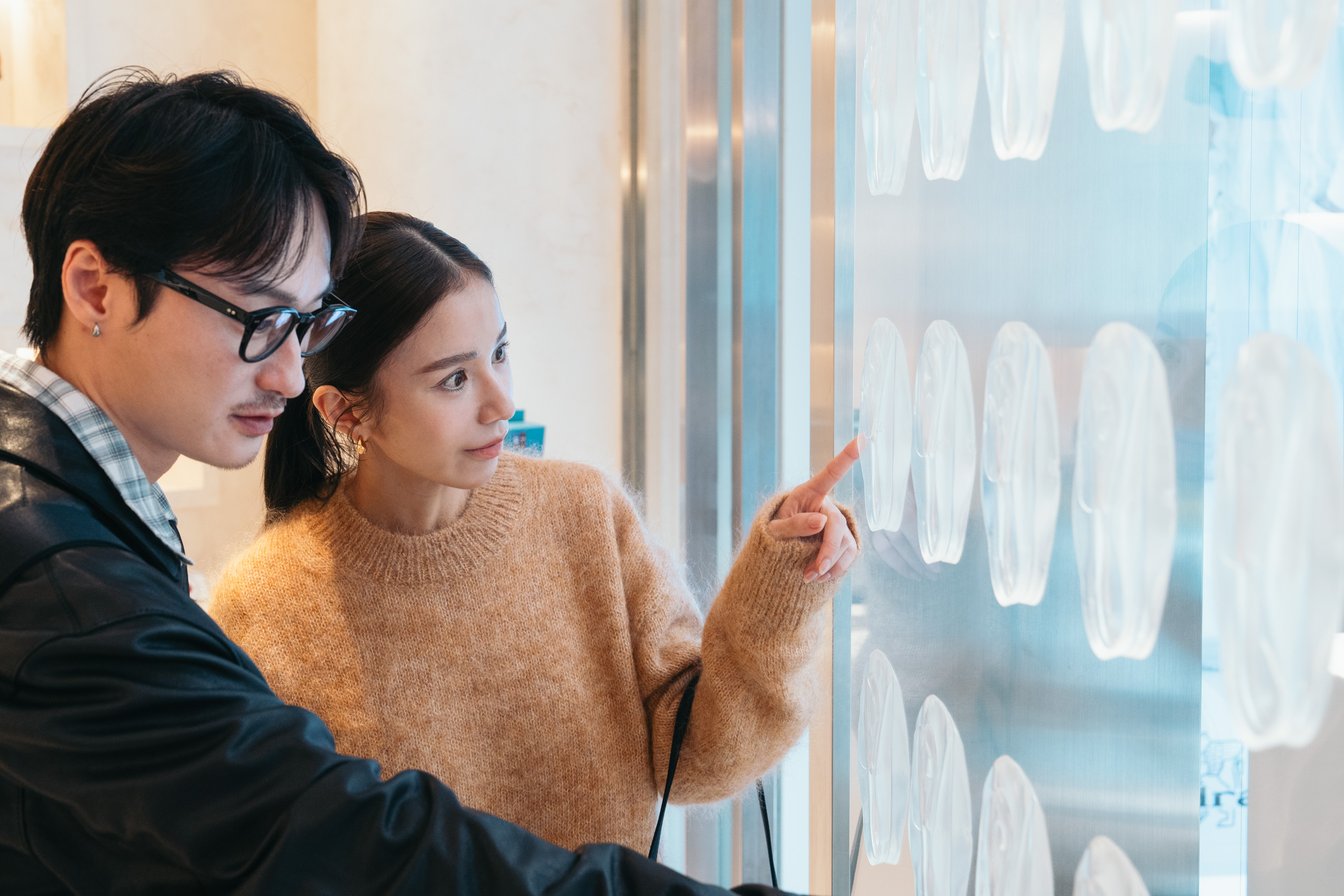 展示されたインソールのゲルを見る2人