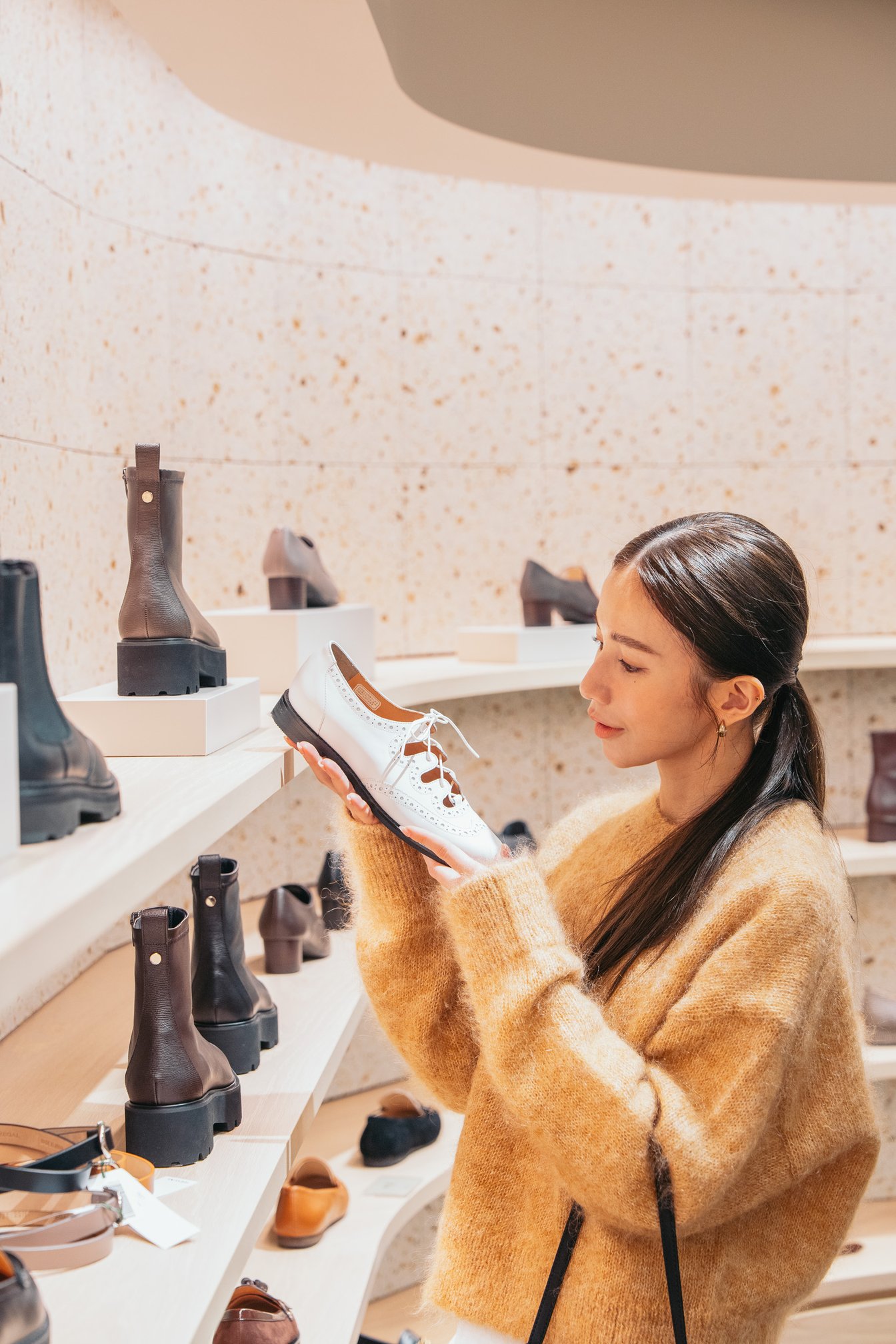 革靴を手にするモデル