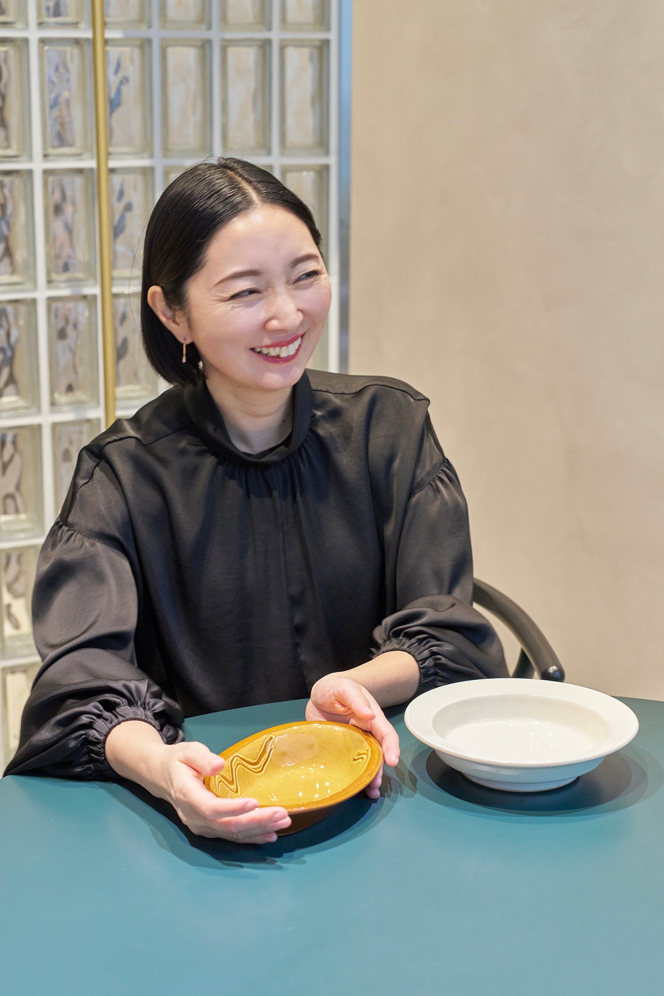 オレンジの器を手に話す山内マリコ