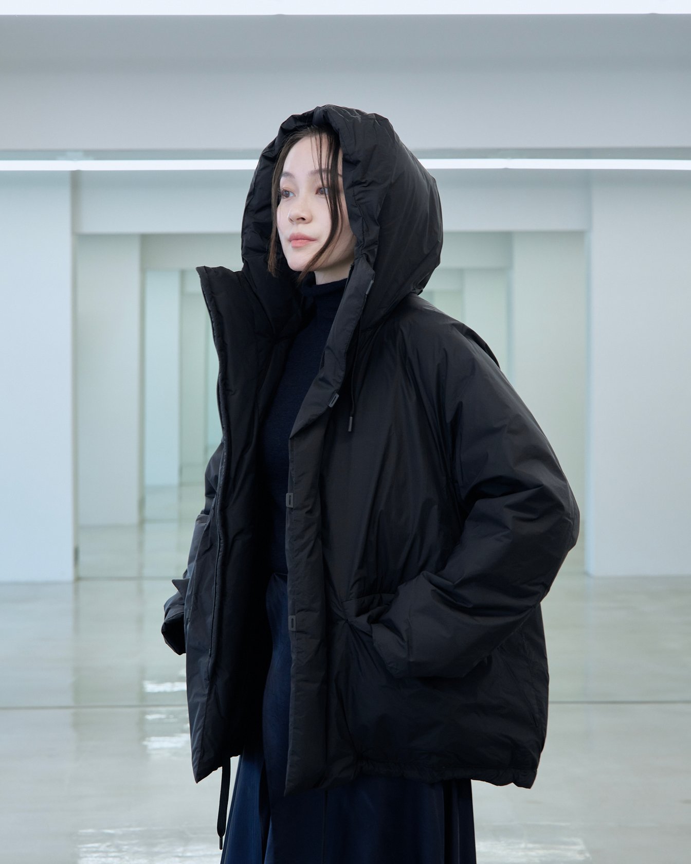 テアトラのダウンアウター「スーベニアハンター」を着用した女性モデル