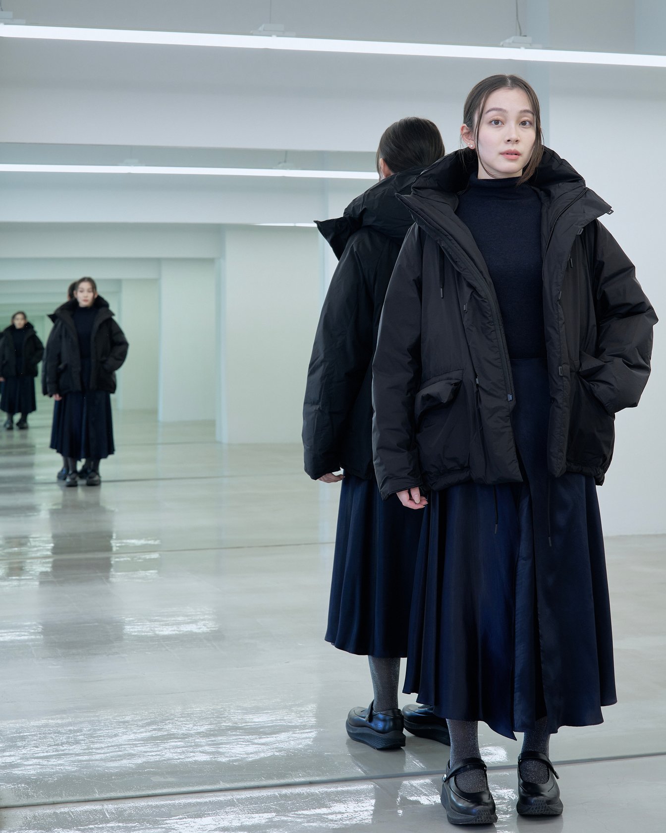 テアトラのダウンアウター「スーベニアハンター」を着用した女性モデル