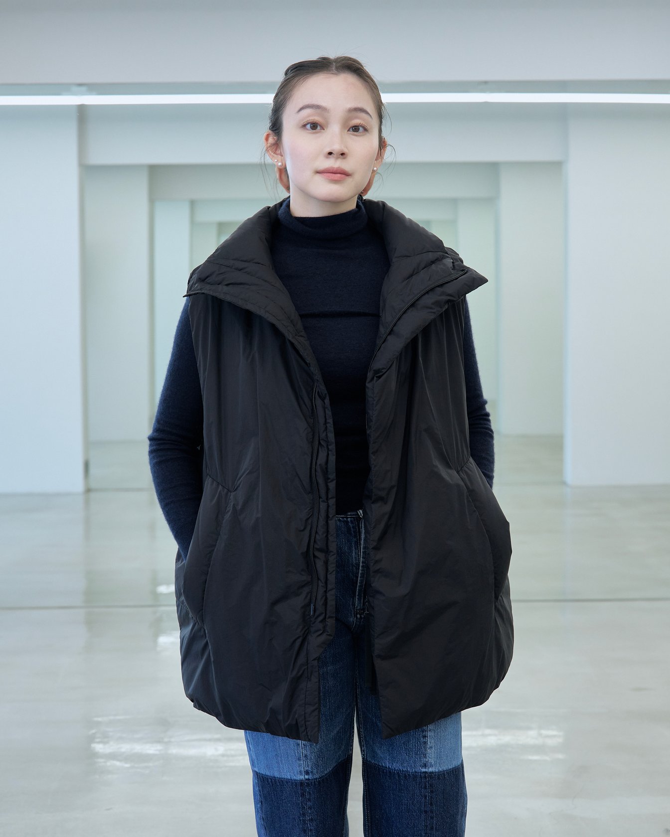 テアトラのダウンベスト「ミュートスコープ ベスト」を着用した女性モデル