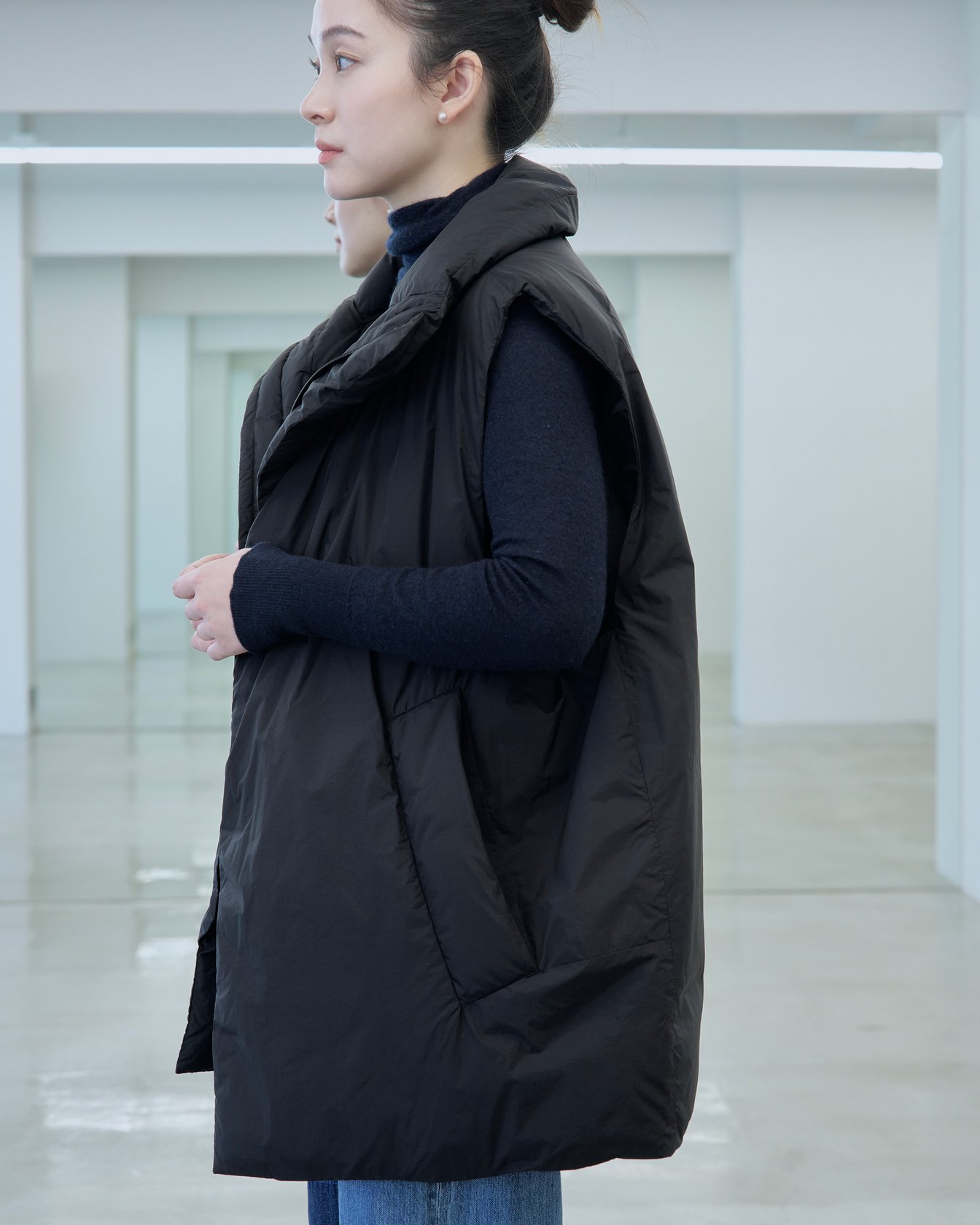 テアトラのダウンベスト「ミュートスコープ ベスト」を着用した女性モデル